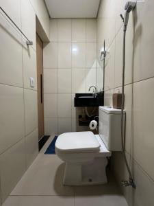 a white bathroom with a toilet and a sink at Casa climatizada a 10 min do AEROPORTO in Várzea Grande