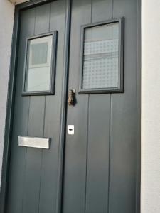 a gray garage door with two windows on it at Yellow House in Tavira