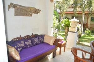 サヌールにあるVakantiehuis-Bali.Nlの紫色のソファと像のあるリビングルーム