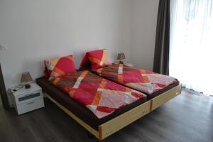 a bedroom with a bed with a colorful quilt on it at Haus Bergtreu in Saas-Grund