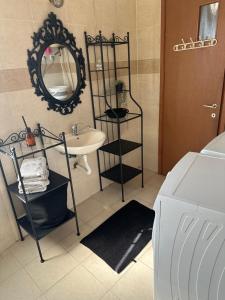 a bathroom with a sink and a mirror and a washing machine at Kyel location in Ashdod