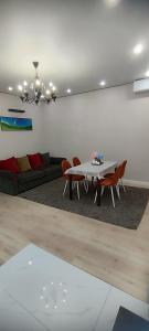 a living room with a table and chairs and a couch at Riviera apartment for 6 persons in Almaty