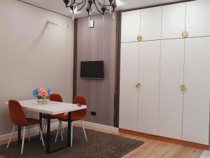 a dining room with white cabinets and a table and chairs at Riviera apartment for 6 persons in Almaty