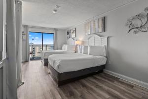 a hotel room with two beds and a balcony at Gorgeous Double Queen Suite! Sleeps 4! Sea Mist 51602 in Myrtle Beach +27 photos