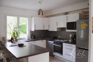 a kitchen with white cabinets and a black counter top at Maison 3chambres aux portes de la Champagne in Essômes-sur-Marne