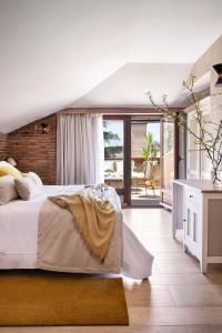a bedroom with a large bed and a balcony at Los Rosales Hotel in El Espinar