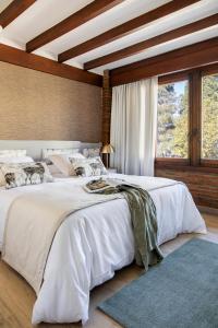 a bedroom with a large white bed and a large window at Los Rosales Hotel in El Espinar