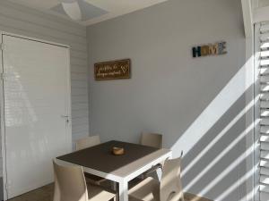 une salle à manger avec une table noire et des chaises blanches dans l'établissement Mio Plage, à Sainte-Anne