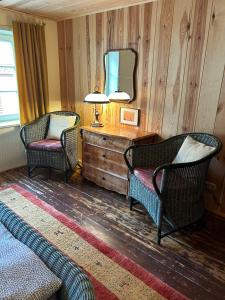 a living room with two chairs and a table and a mirror at Das Brunnenhaus in Tangermünde