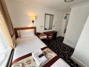a hotel room with a bed and a desk at Andorra Guest Accommodation in Brighton & Hove