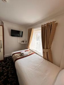 a hotel room with a bed with a window at Andorra Guest Accommodation in Brighton & Hove