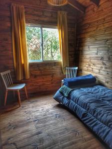 a bedroom with a bed and a window in a log cabin at Cabaña Megara en Complejo Marea in Tigre +17 photos