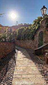 Un camino de piedra junto a un muro de piedra con una farola. en Appartamento villa del borgo, en Deiva Marina