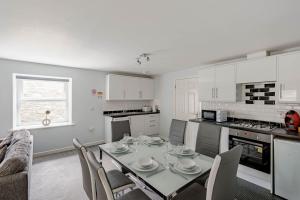 a kitchen and dining room with a table and chairs at Auchenlarie Courtyard No 3 in Gatehouse of Fleet