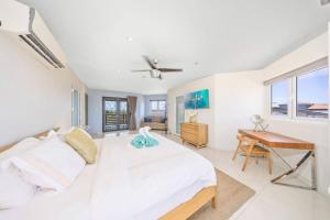 a white bedroom with a bed and a desk at Villa Sol Y Luna - Near Malmok Beach By Lucha in Palm-Eagle Beach +87 photos