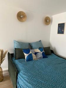 a bedroom with a bed with blue sheets and pillows at Bel appartement neuf proche de Paris in Maisons-Laffitte