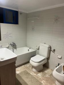 a bathroom with a toilet and a tub and a sink at Almeta Apartment 2 in Chios