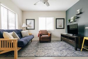 a living room with a blue couch and a tv at Secluded Beach Adventure Cabana - Newly Renovated! in Pompano Beach