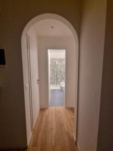 an empty hallway with an archway leading to a bathroom at LA Casa BIANCA e blu in Rapallo +3 photos