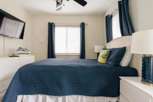 a bedroom with a blue bed and a window at Secluded Beach Adventure Cabana - Newly Renovated! in Pompano Beach