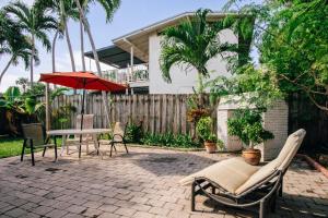 a patio with a table and chairs and an umbrella at Secluded Beach Adventure Cabana - Newly Renovated! in Pompano Beach