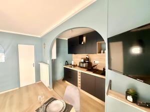 a kitchen with blue walls and a table in a room at Flamingo Vibes, central et élégant in Limoges