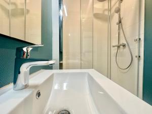a white sink in a bathroom with a shower at Flamingo Vibes, central et élégant in Limoges