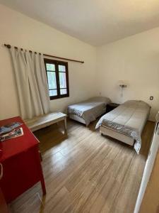 a bedroom with two beds and a red table at Ascochinga, Cordoba, Argentina - Estancia de Polo in Ascochinga +1 photo