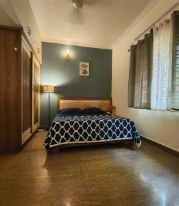 a bedroom with a bed with a blue and white comforter at Flickstays Acacia in Bangalore