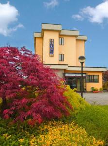a building with a bunch of flowers in front of it at Hotel Majestic in San Giuliano Milanese