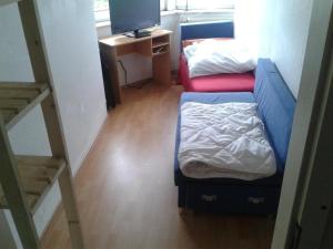 a small room with two beds and a television at MonteurRoomMR in Essen