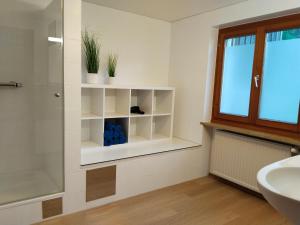a bathroom with white shelves and a sink at am Fluhbach in Mellau +5 photos