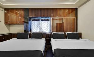 a room with two beds and a window at Medi Konda Grand in Nellore