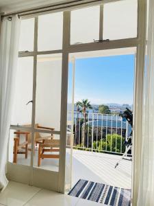 a room with a sliding glass door with a view of the ocean at Villa Saarchi Apartments in Windhoek