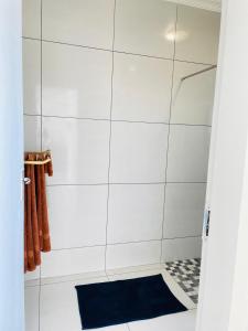 a bathroom with a shower with a blue rug at Villa Saarchi Apartments in Windhoek +15 photos
