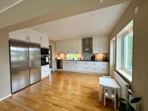 a large kitchen with white cabinets and a wooden floor at Villa Nina in Sävsjö