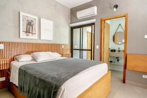 a bedroom with a large bed and a mirror at JQY Beach Flats - 950m da Praia - Garagem subterrânea - Estação de carregamento para veículos elétricos in Juquei