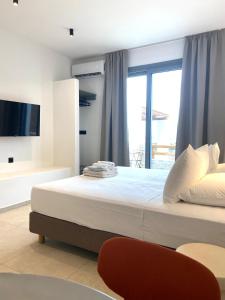 a bedroom with a large bed with a window at Spanos Apartments in Agios Petros +37 photos
