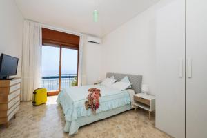 Un dormitorio con una cama y un televisor y un balcón. en Skyview Paradise House, en Amalfi 12 fotos más