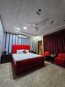 a bedroom with a red bed and a red couch at Hotel Tulip Inn, Gulberg in Lahore