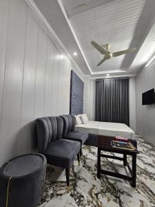 a room with a bed and a couch and a table at Hotel Tulip Inn, Gulberg in Lahore