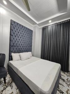 a bedroom with a large bed and a chair at Hotel Tulip Inn, Gulberg in Lahore