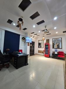 a living room with a table and a tv on a ceiling at Hotel Tulip Inn, Gulberg in Lahore