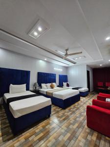 a hotel room with two beds and a red couch at Hotel Tulip Inn, Gulberg in Lahore