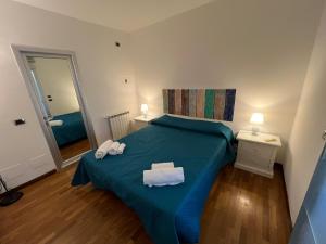 een slaapkamer met een blauw bed met handdoeken erop bij Mondello Tolomea guest house in Mondello
