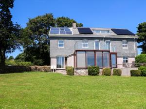 una casa con paneles solares en el techo en The Crows Nest, en Falmouth