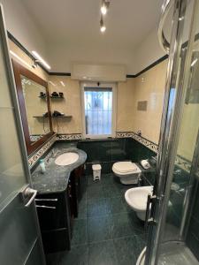 een badkamer met 2 wastafels, een toilet en een douche bij Mondello Tolomea guest house in Mondello