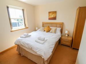 Un dormitorio con una cama con toallas. en The Crows Nest, en Falmouth
