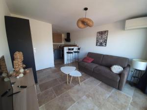 a living room with a couch and a table at Studio au calme tout équipé in Pourrières