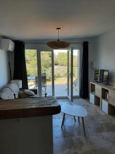 a living room with a bed and a table at Studio au calme tout équipé in Pourrières